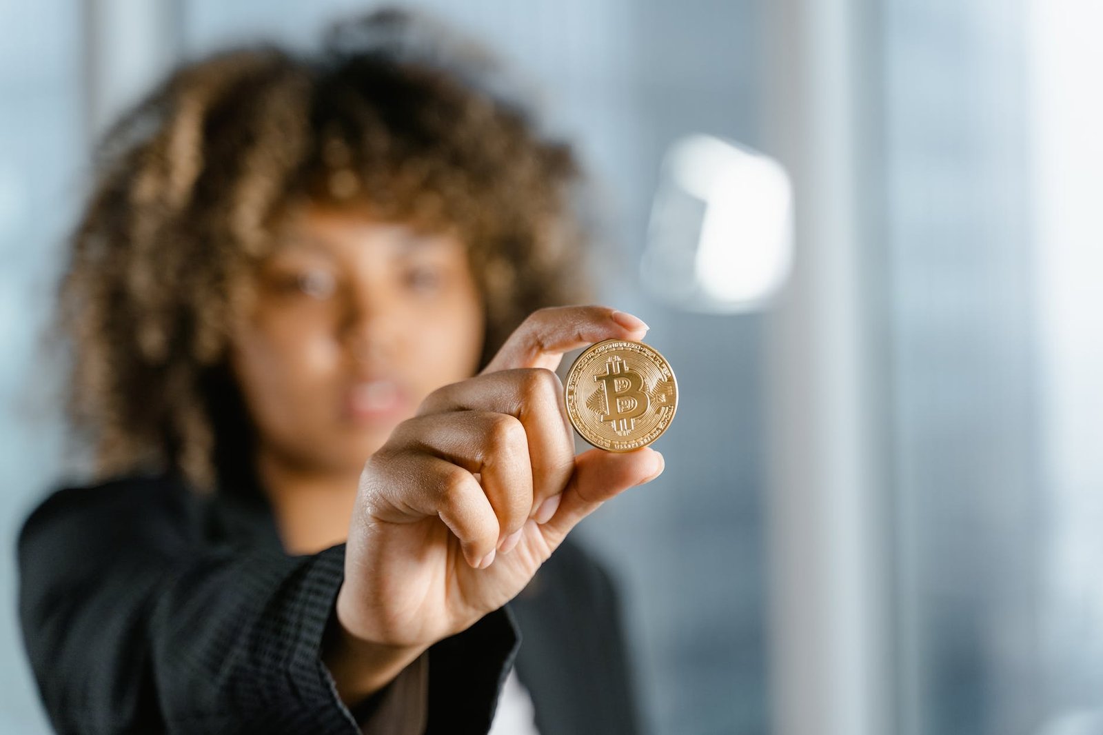 person holding gold round coin